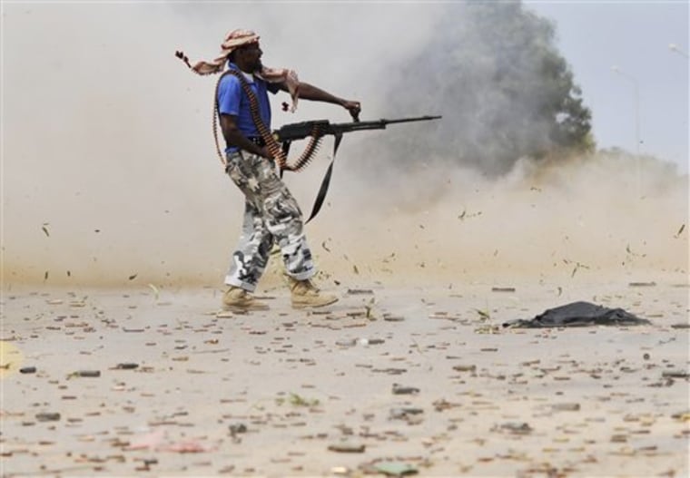 A Libyan revolutionary fighter fires his machine gun while attacking pro-Gadhafi forces inside the Ouagadougou conference center in Sirte, Libya, on Friday. 